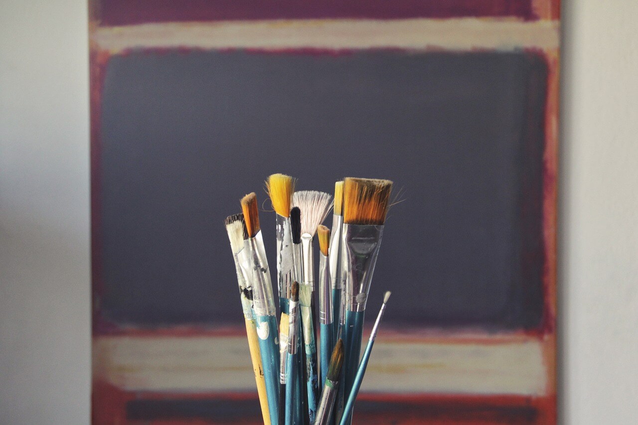 Artwork on wall and paint brushes
