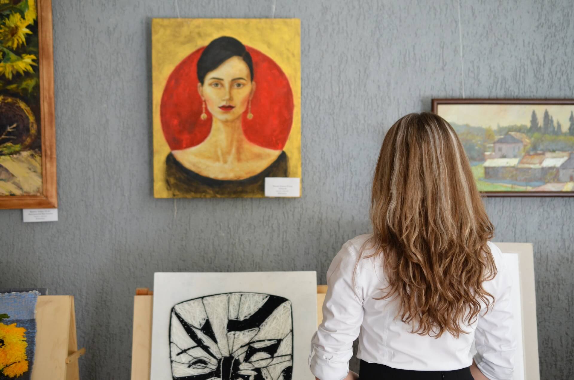 woman looking at art piece for sale